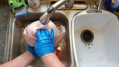 Rinse the turkey and prepare it for grilling (tuck skin, reconnect legs).