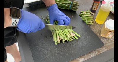 Remove rubber bands from asparagus bundles and lay them in the grill pan.