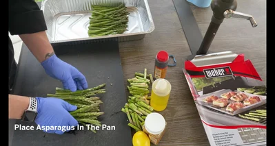 Remove rubber bands from asparagus bundles and lay them in the grill pan.