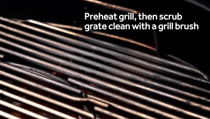 Scrub the grate clean of any built-up char and gunk using a grill brush.