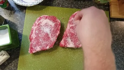 Season with salt, pepper, and garlic powder. Pat the seasoning into the meat.