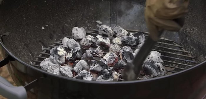Arrange for cooking: Once the briquettes are fully ignited, spread them out evenly, dividing them down the middle, and place the grill grate on top.