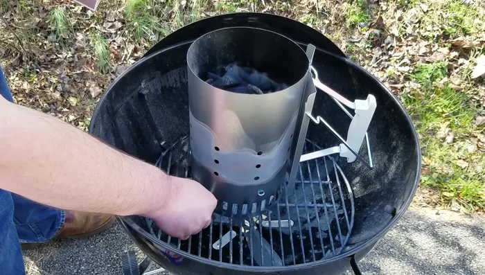 Light the charcoal: Light the newspaper at the bottom of the chimney.