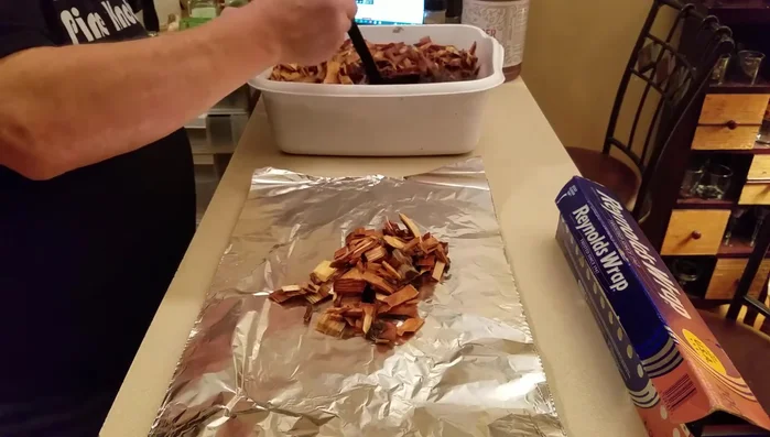 Prepare wood chip packets: Soak wood chips (applewood and maple) for about 45 minutes. Place them in double layers of aluminum foil, poke holes for ventilation, and create small packets.