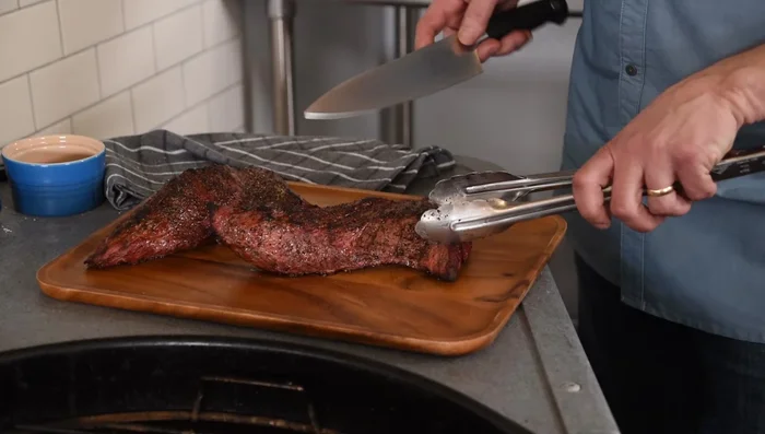 Slice the tri-tip *against the grain*. First, slice the tri-tip in half lengthwise (with the grain). Then, slice each half against the grain for tender, juicy results.