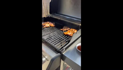 Add barbecue sauce to chicken thighs and continue grilling over indirect heat until internal temperature reaches 165°F.