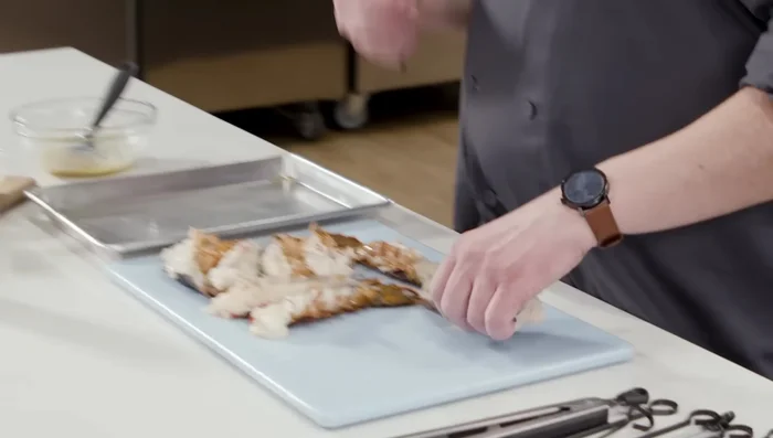 Skewer the Lobster: Thread each lobster tail onto a skewer, going through the back and up to the tail section. This keeps the lobster from curling during grilling and makes flipping easier.