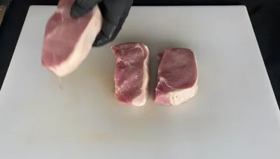 Season Pork Chops: Apply yellow mustard as a binder to help seasoning stick. Generously coat with your favorite barbecue rub.