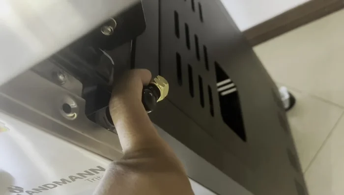 Attach the hose and regulator (not included with the grill) to the gas tank and grill.