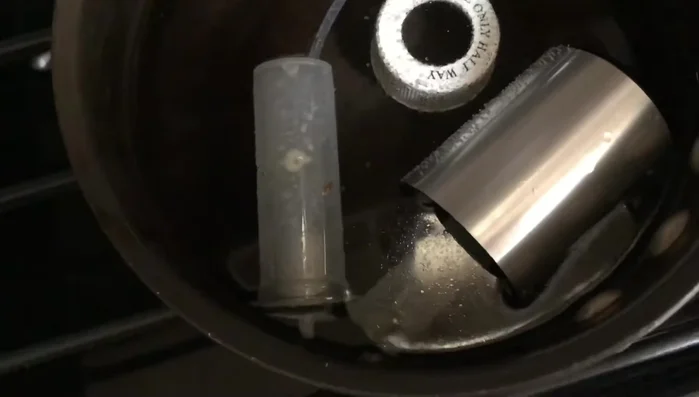 Empty the bottle and put it upside down to clean the head. 