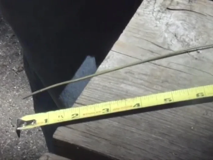 Bend the ends of the coat hanger wire segments on the opposite side to secure the grate.