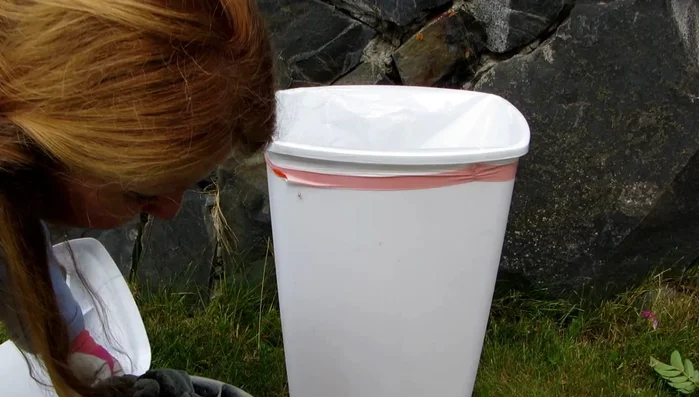 Pour the charcoal into the plastic bag inside the container.