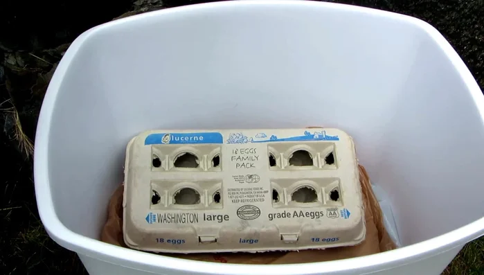 Pour charcoal lighter fluid into the container.