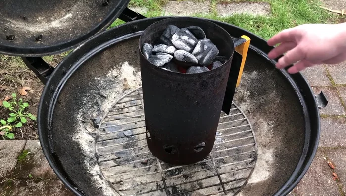 Empty and distribute: Pour out the charcoal and spread it evenly across the grill.