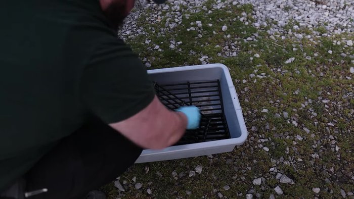 Using a stiff sponge and warm water, scrub the grates to remove the residue. The porcelain is non-stick, so it shouldn't require excessive scrubbing.