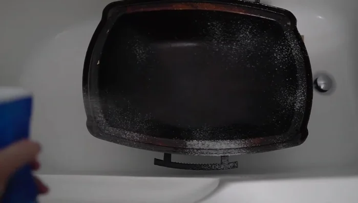 Scrub the grill components with a sponge.