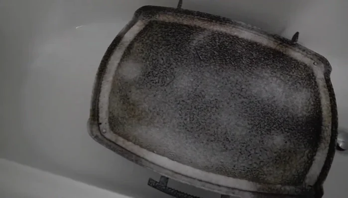 Scrub the grill components with a sponge.