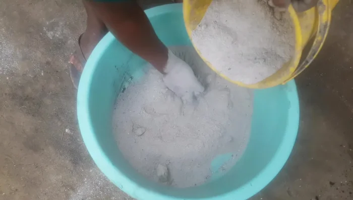 Add the sifted charcoal dust to the ash paste and mix thoroughly until a stiff, moldable consistency is achieved.