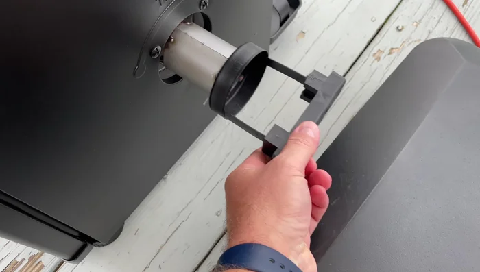 Add the hickory chips to the tray, keeping the tray upright to avoid spillage.