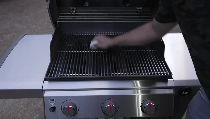 Season grill grates with high-temperature cooking oil.