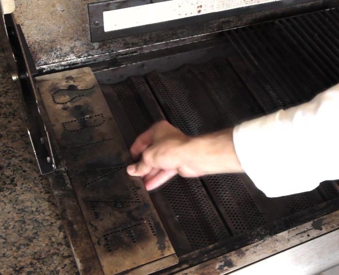 Turn the burner under the smoker box on high. Place a surface thermometer in the opposite rear corner of the grill.