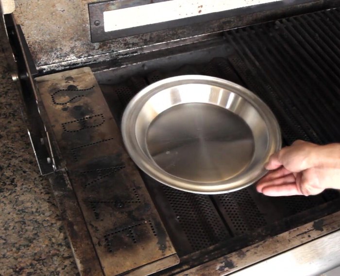 Turn the burner under the smoker box on high. Place a surface thermometer in the opposite rear corner of the grill.