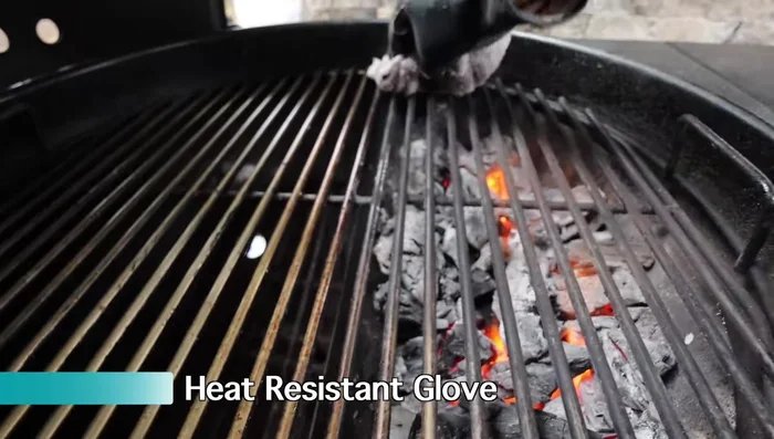 Fold the towel and wipe the hot grill grates.