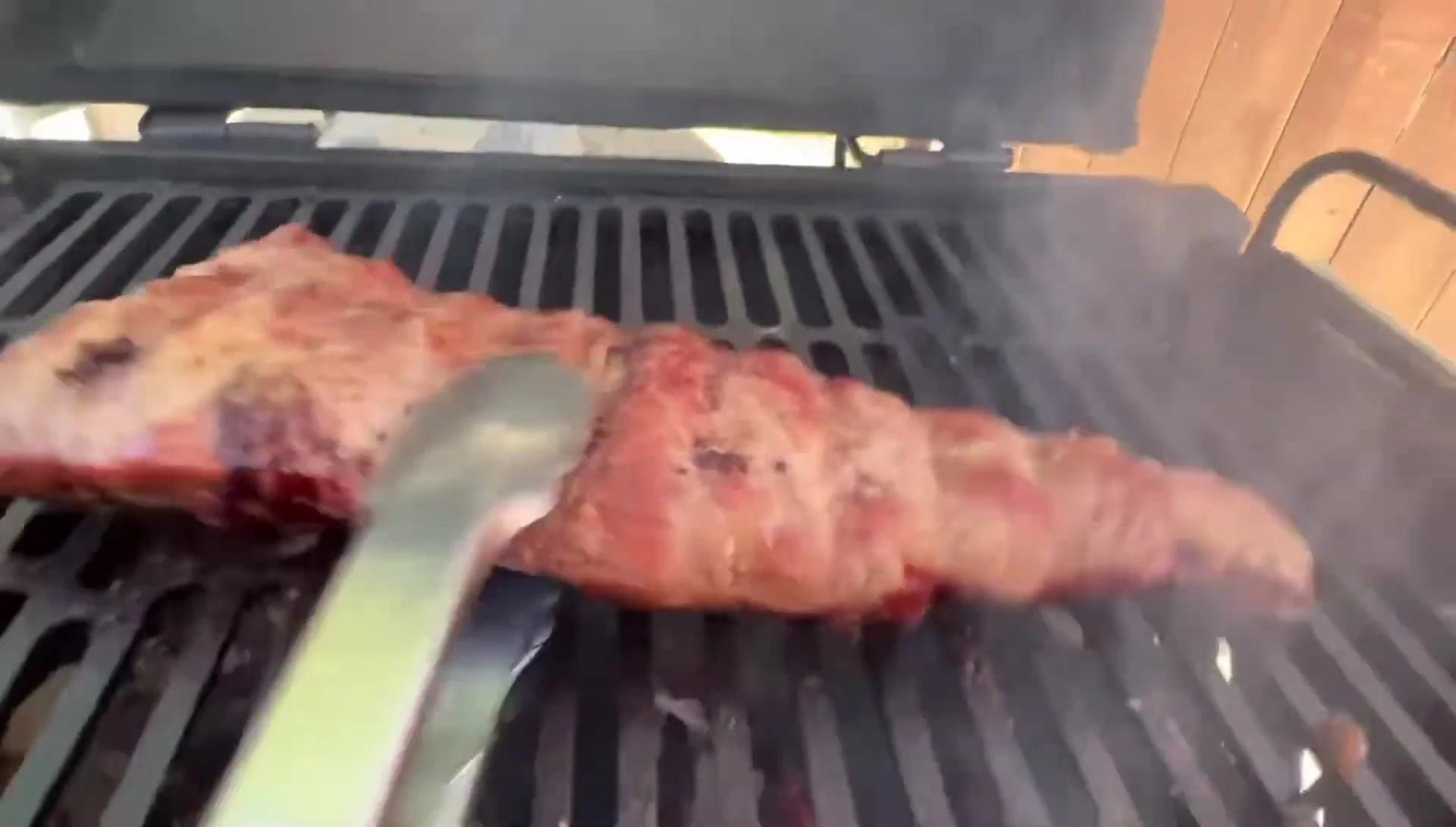 Grilled ribs on barbecue, charring beautifully.