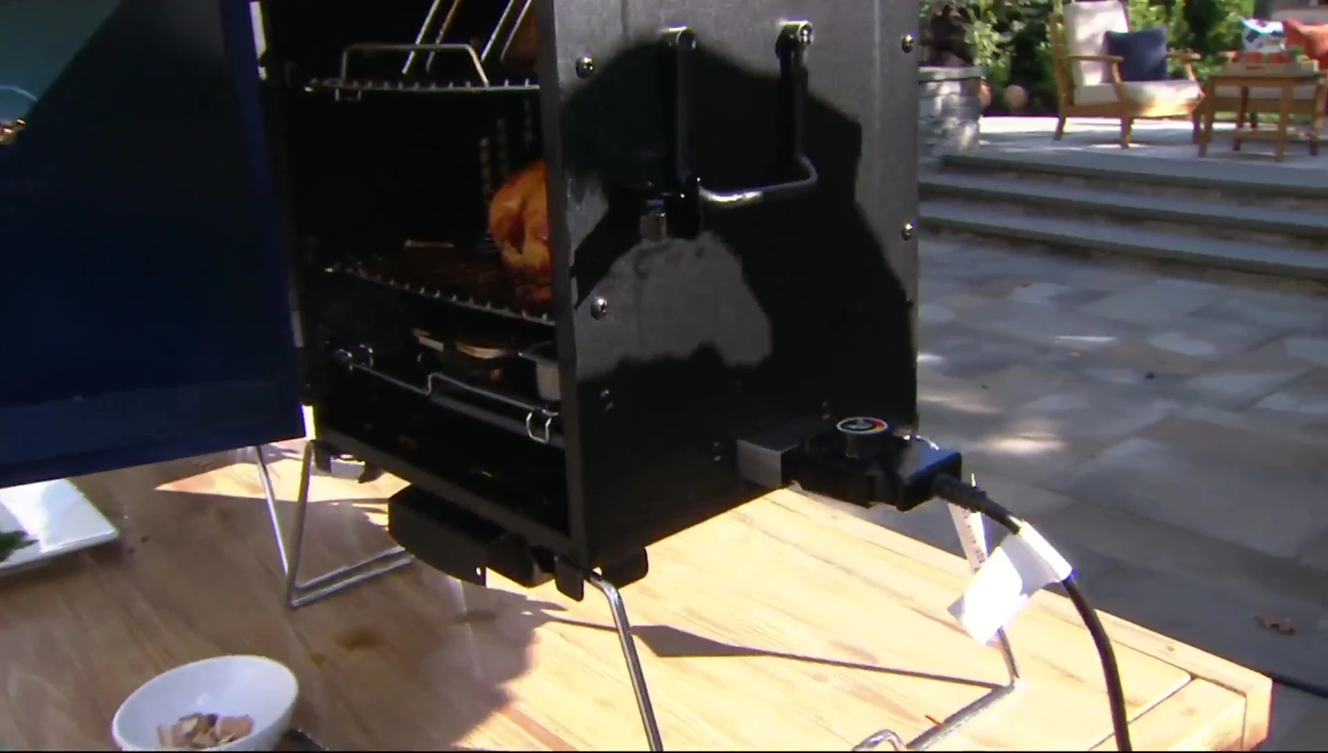 Electric smoker cooking chicken outdoors