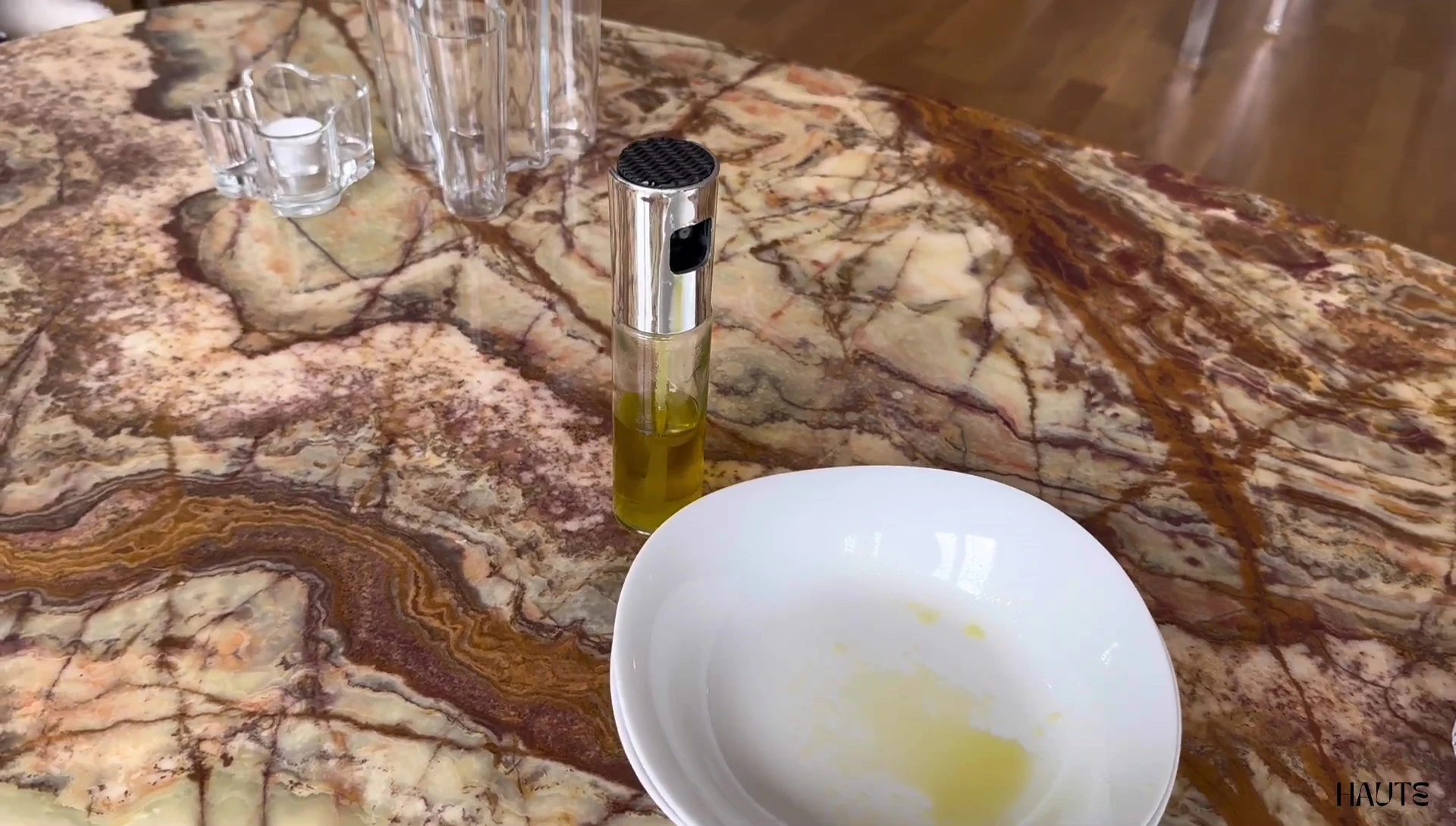 Olive oil sprayer bottle on marble table