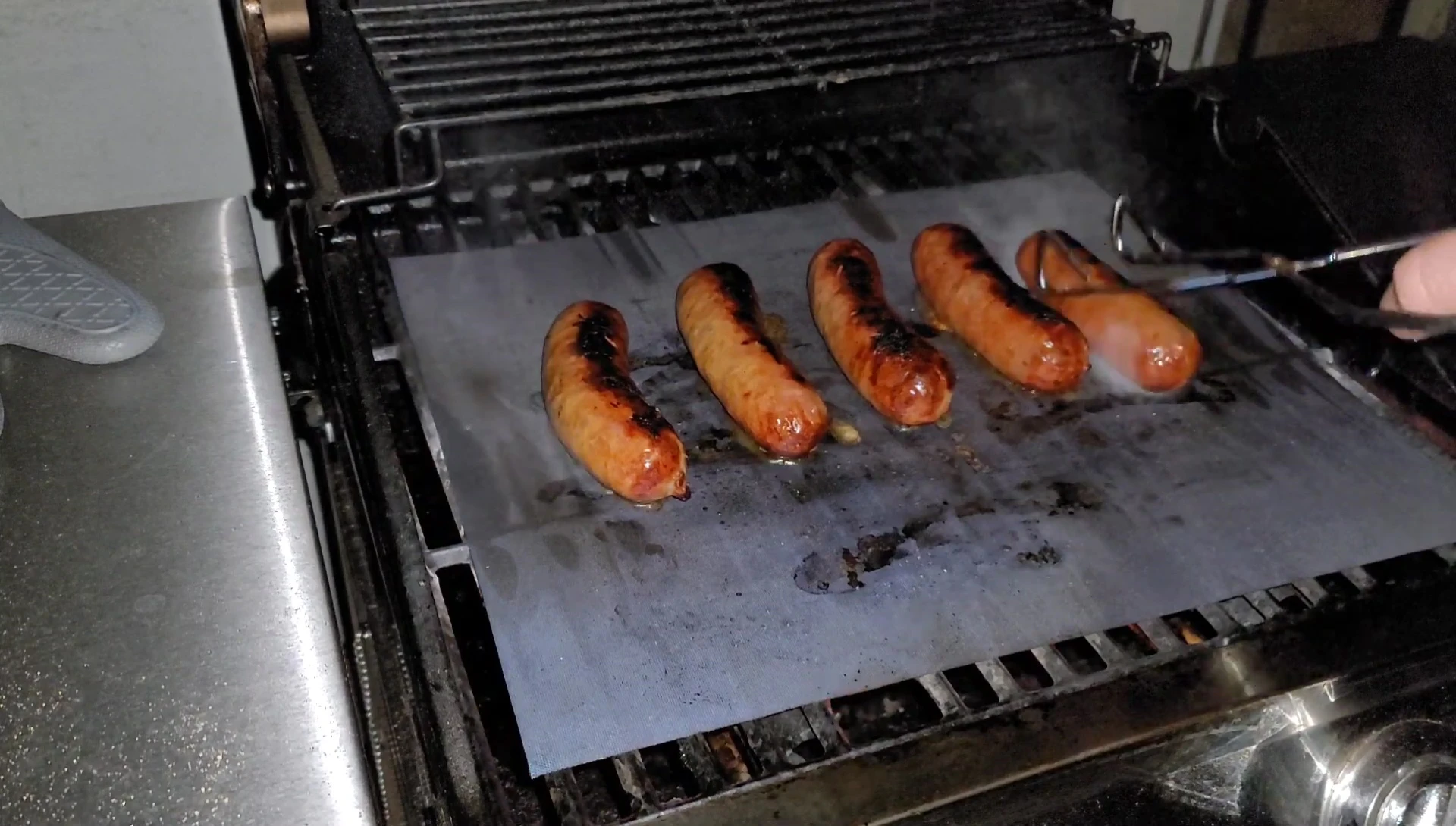 Italian sausages grilling on mat