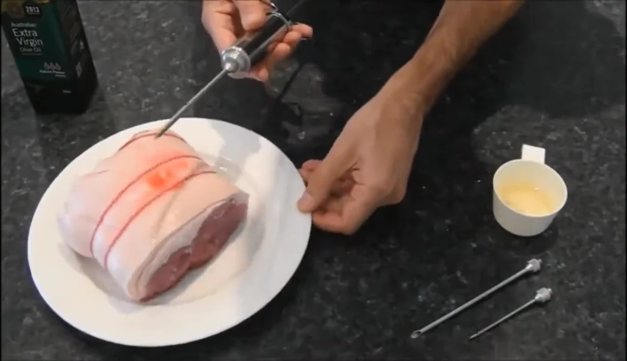 Injecting marinade into meat with needle.