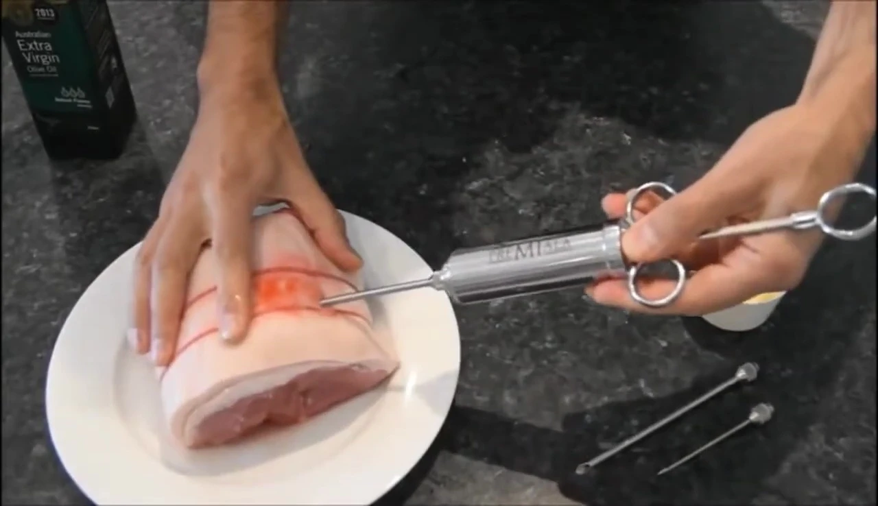 Injecting marinade into meat with syringe