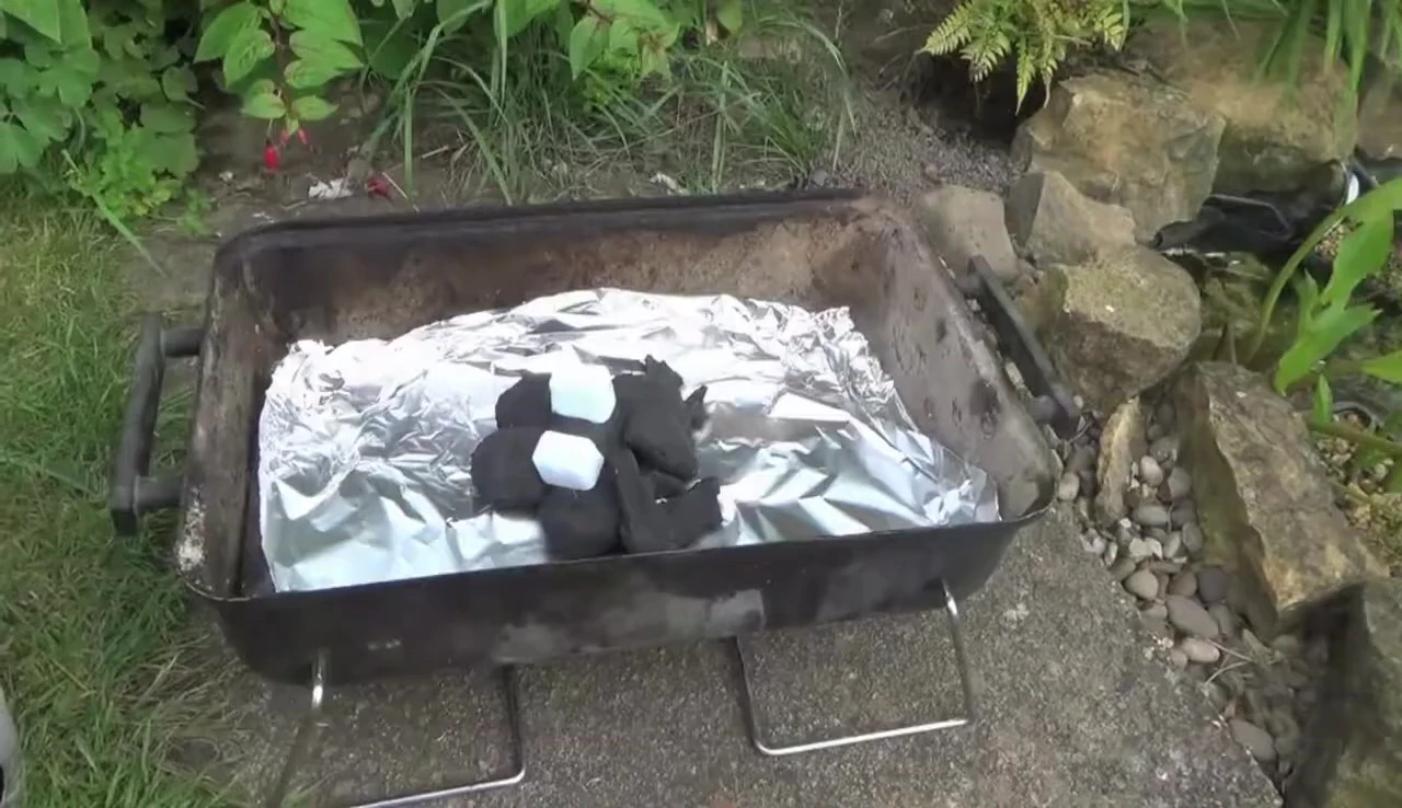 Portable charcoal chimney starter in use