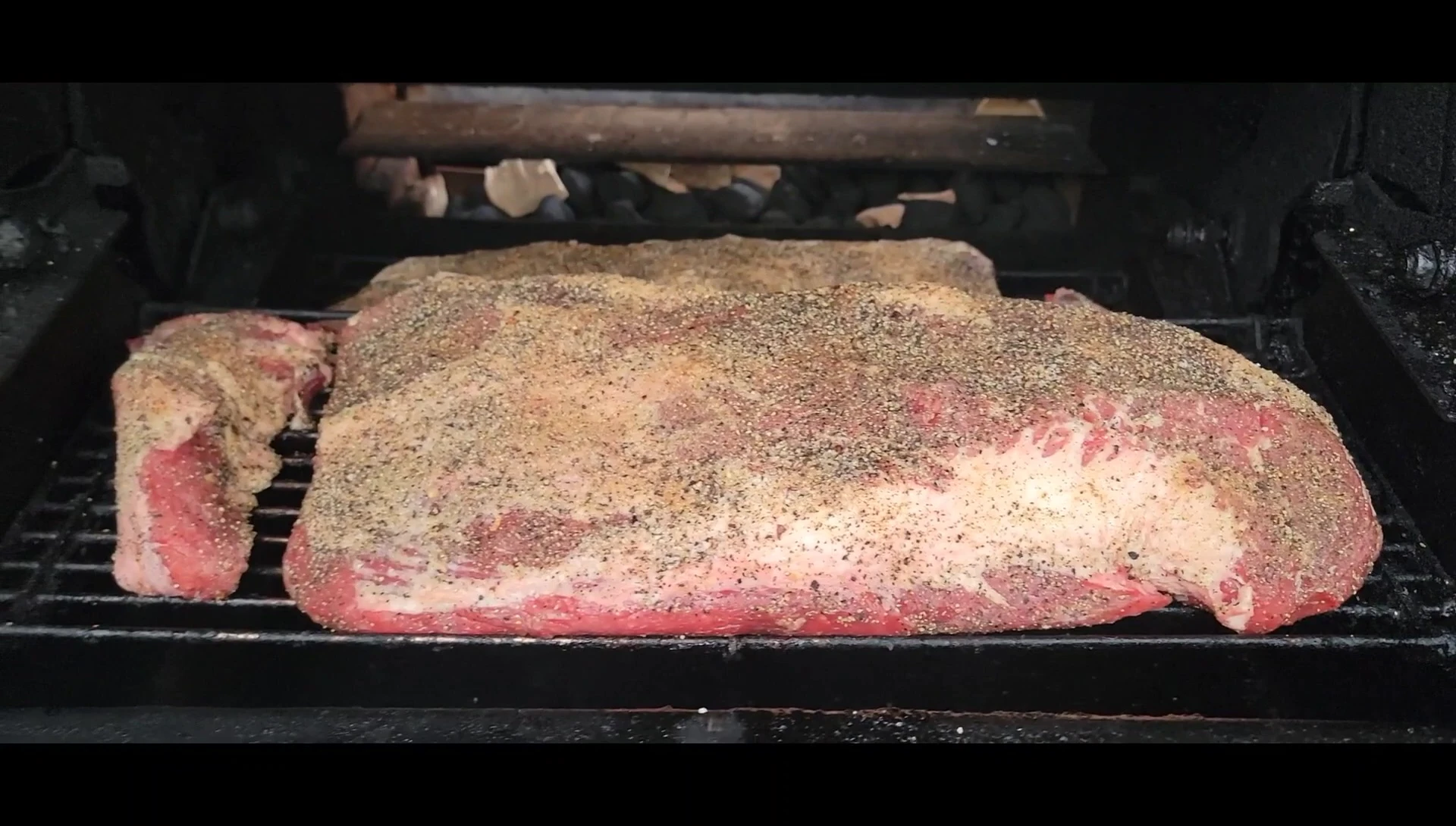 Seasoned briskets on smoker grill