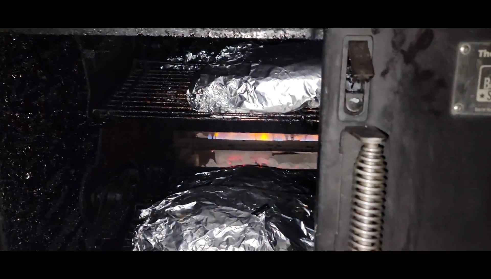 Foil-wrapped briskets resting in smoker