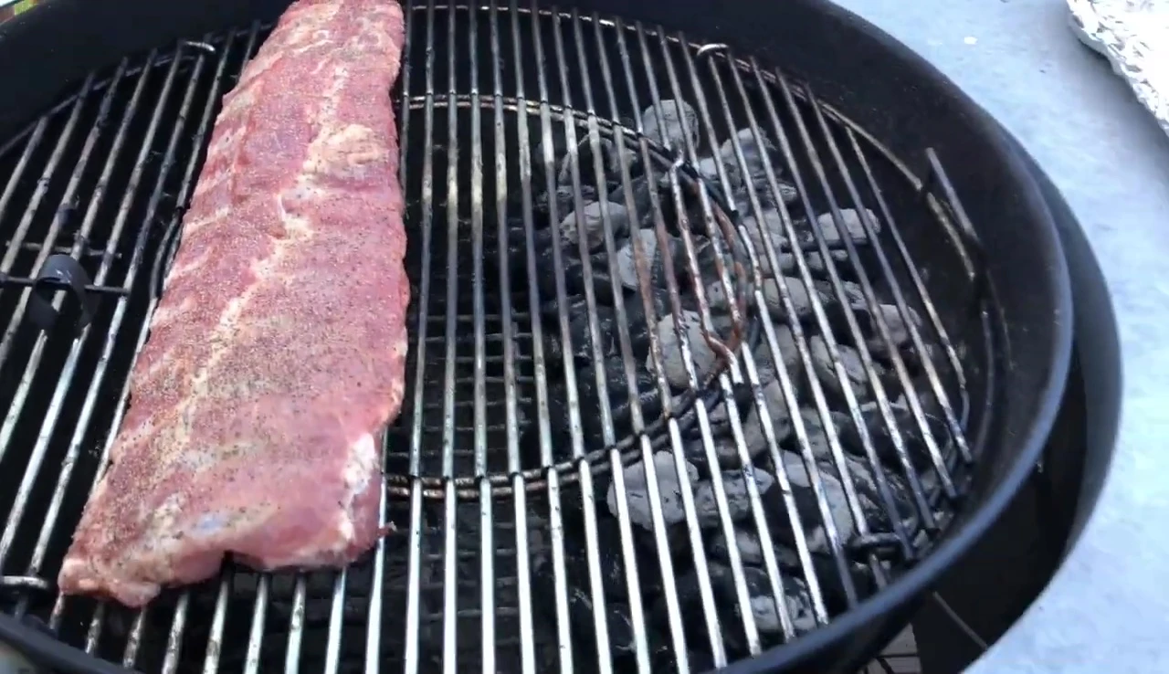 Charcoal grill cooking ribs at 250°F