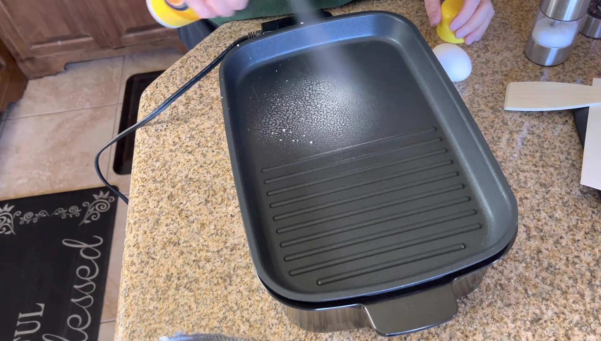 The reviewer lightly oiling the griddle surface.
