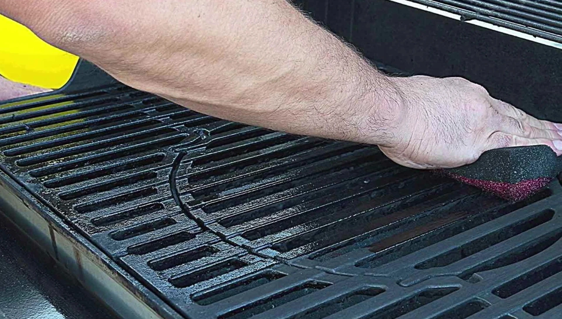 Cleaning cast iron grill with cleaner.