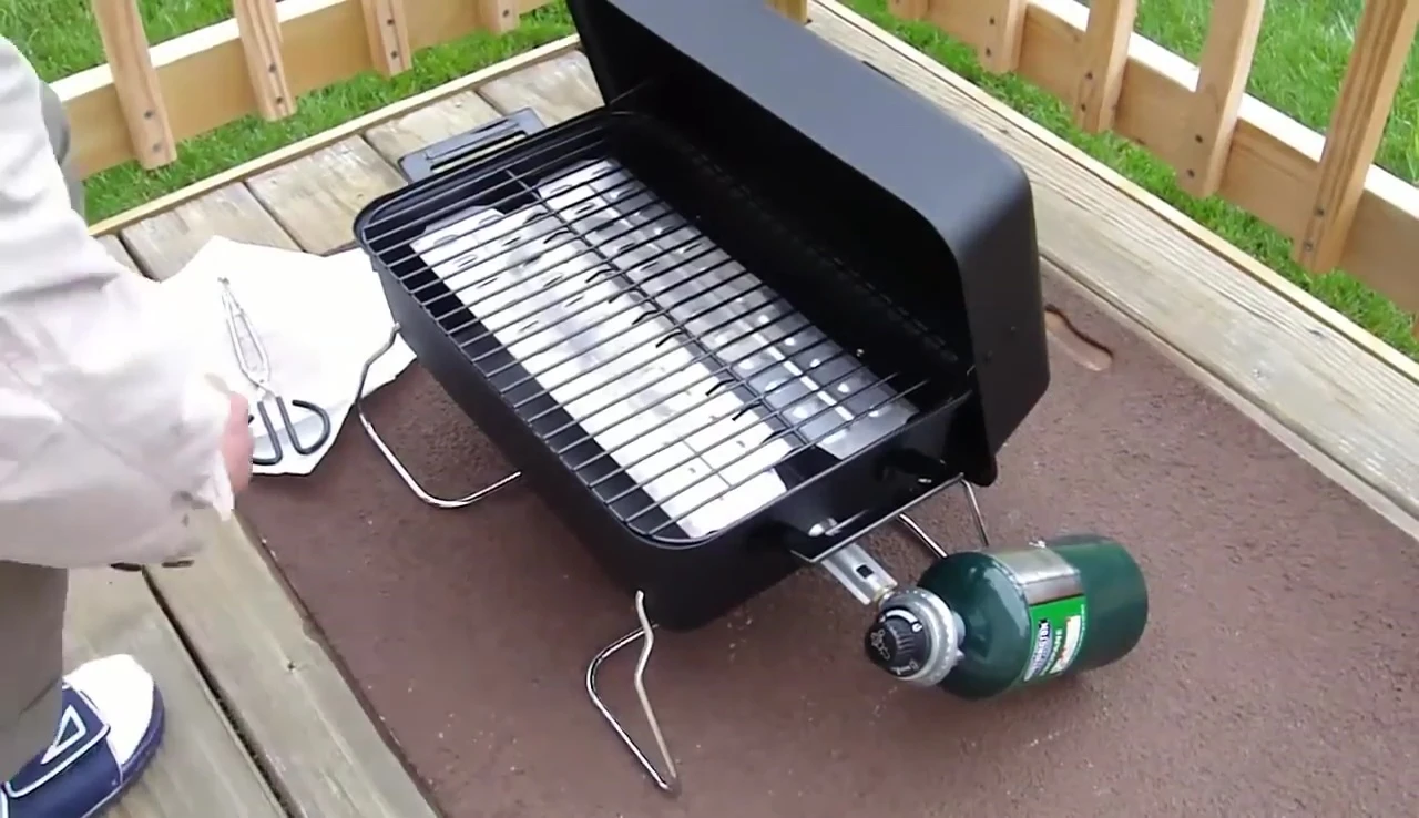 Placing hot dogs on the grill grates.