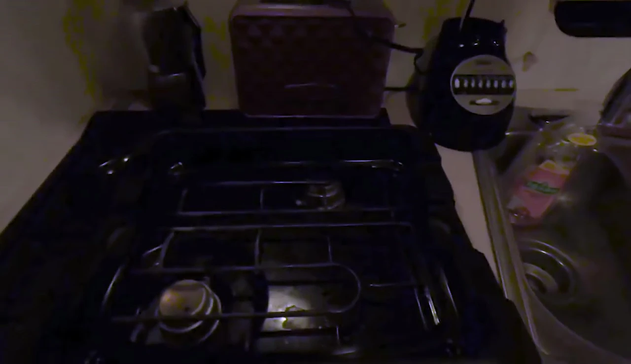 Close-up shot of the grill's plastic base and metal drip tray.