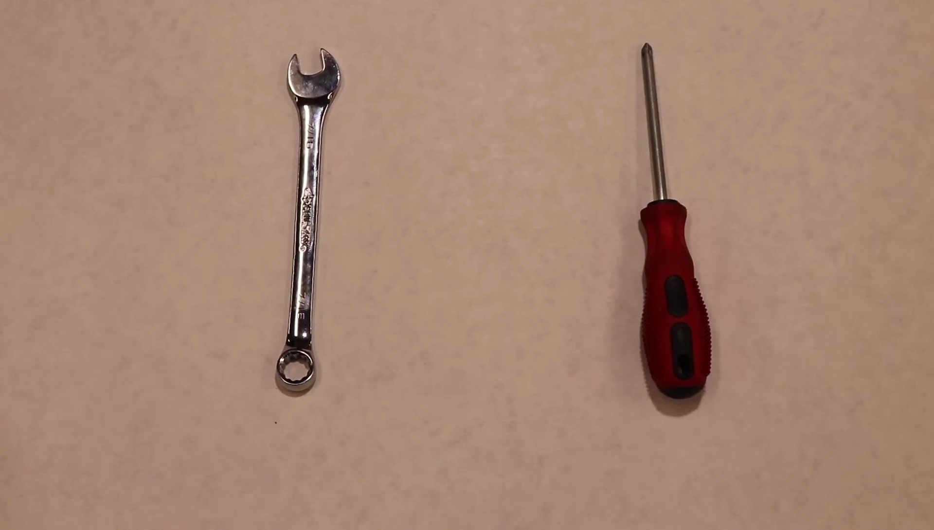 Close-up shot of the required tools: 7/16 wrench, Phillips head screwdriver, drill, and tape measure.