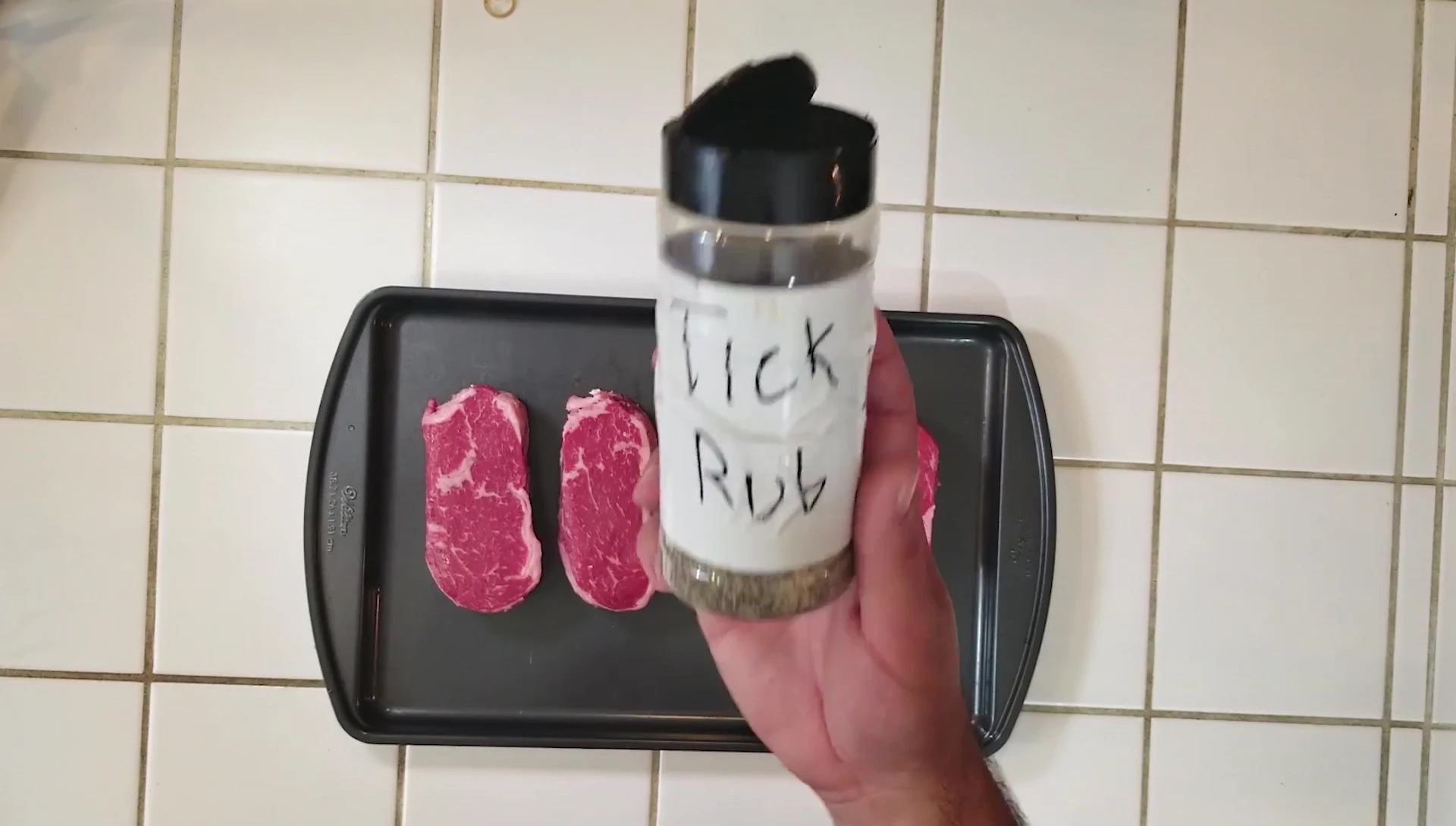 Seasoning the steaks with salt and pepper.