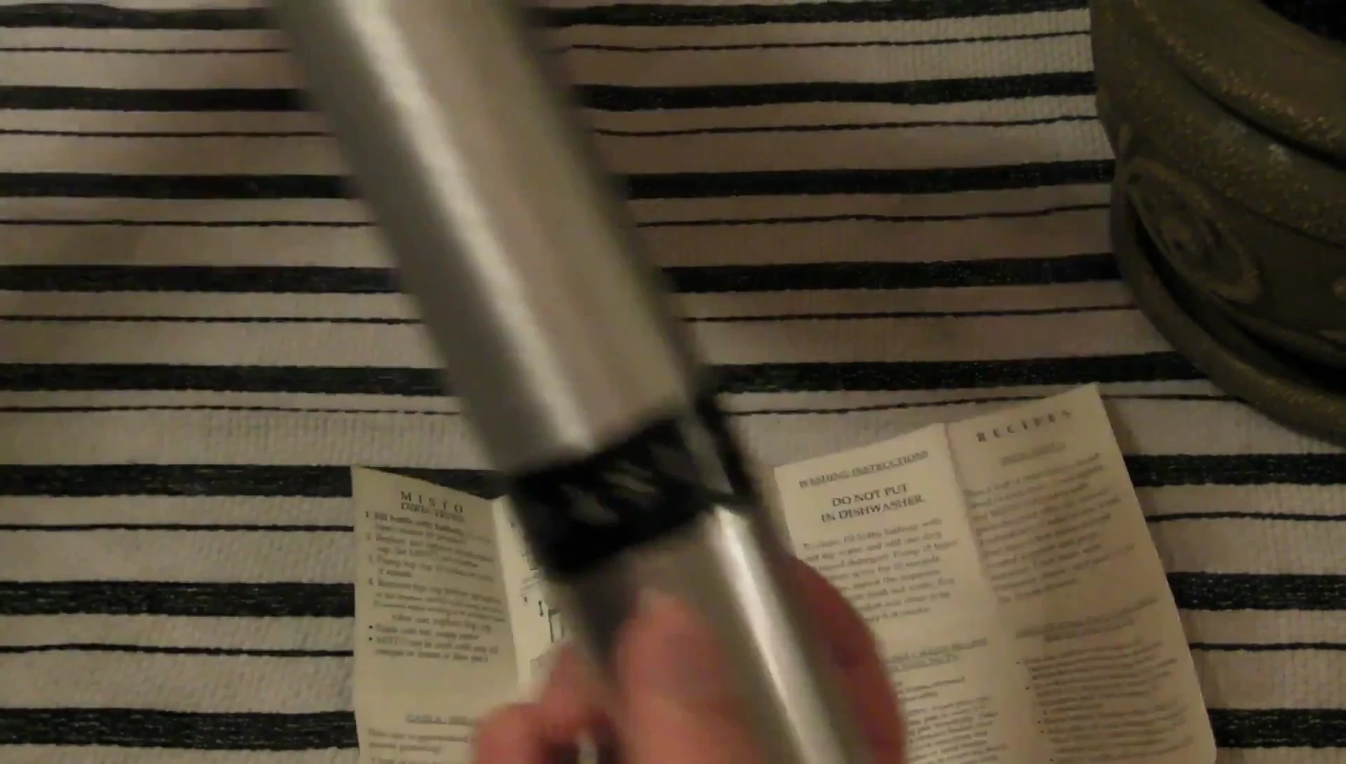 Close-up of the sleek, brushed aluminum sprayer.