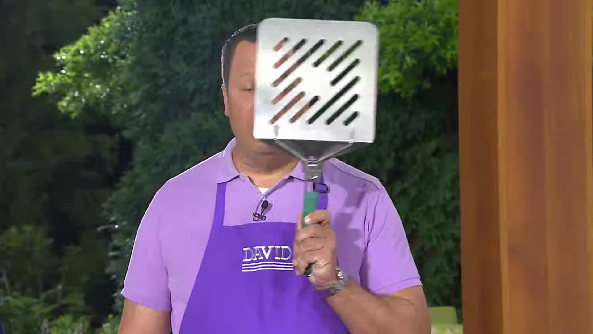 Close-up of the oversized spatula next to a person's head for size comparison.
