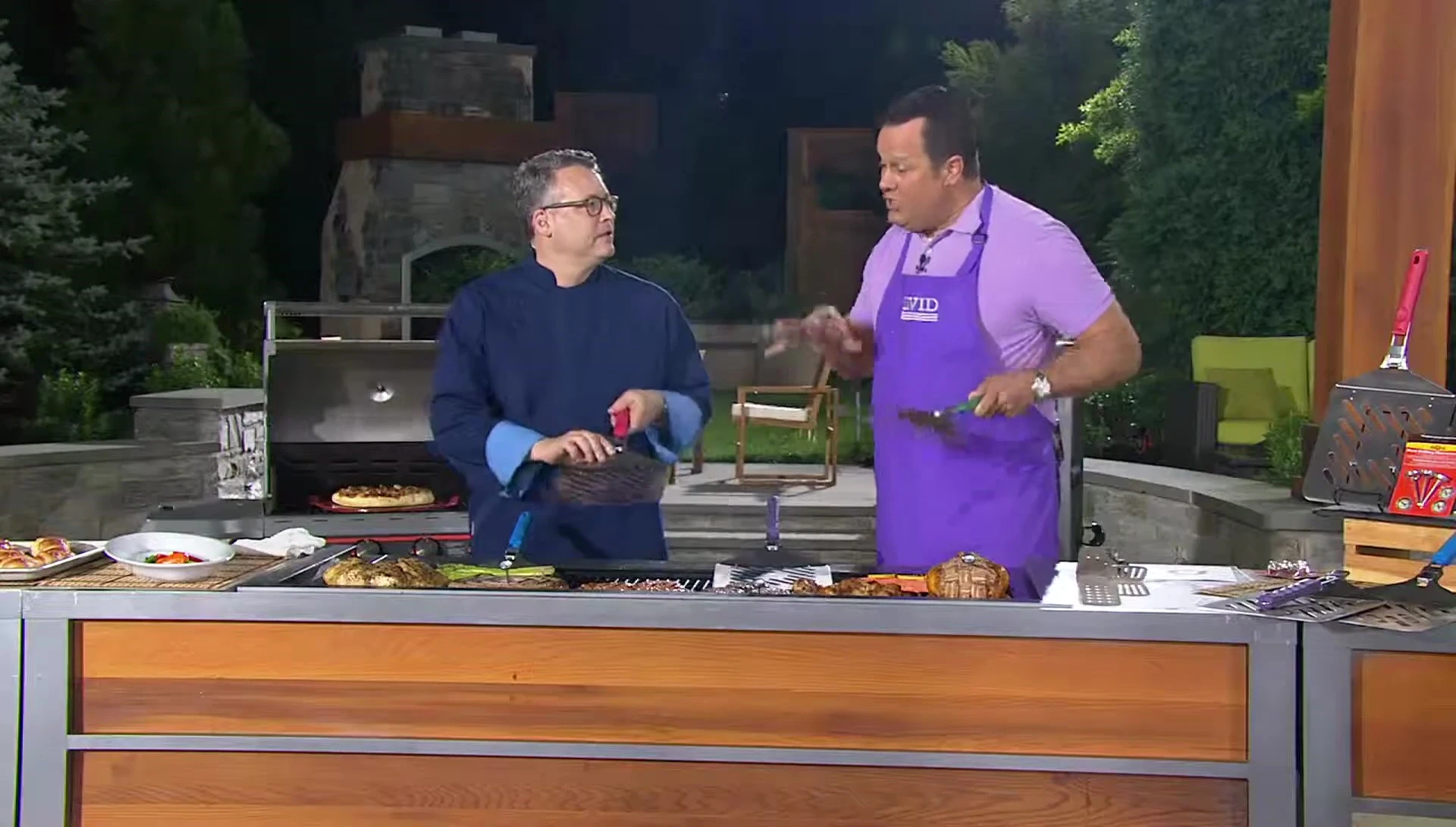 The spatula being used to flip multiple pieces of food on a grill.