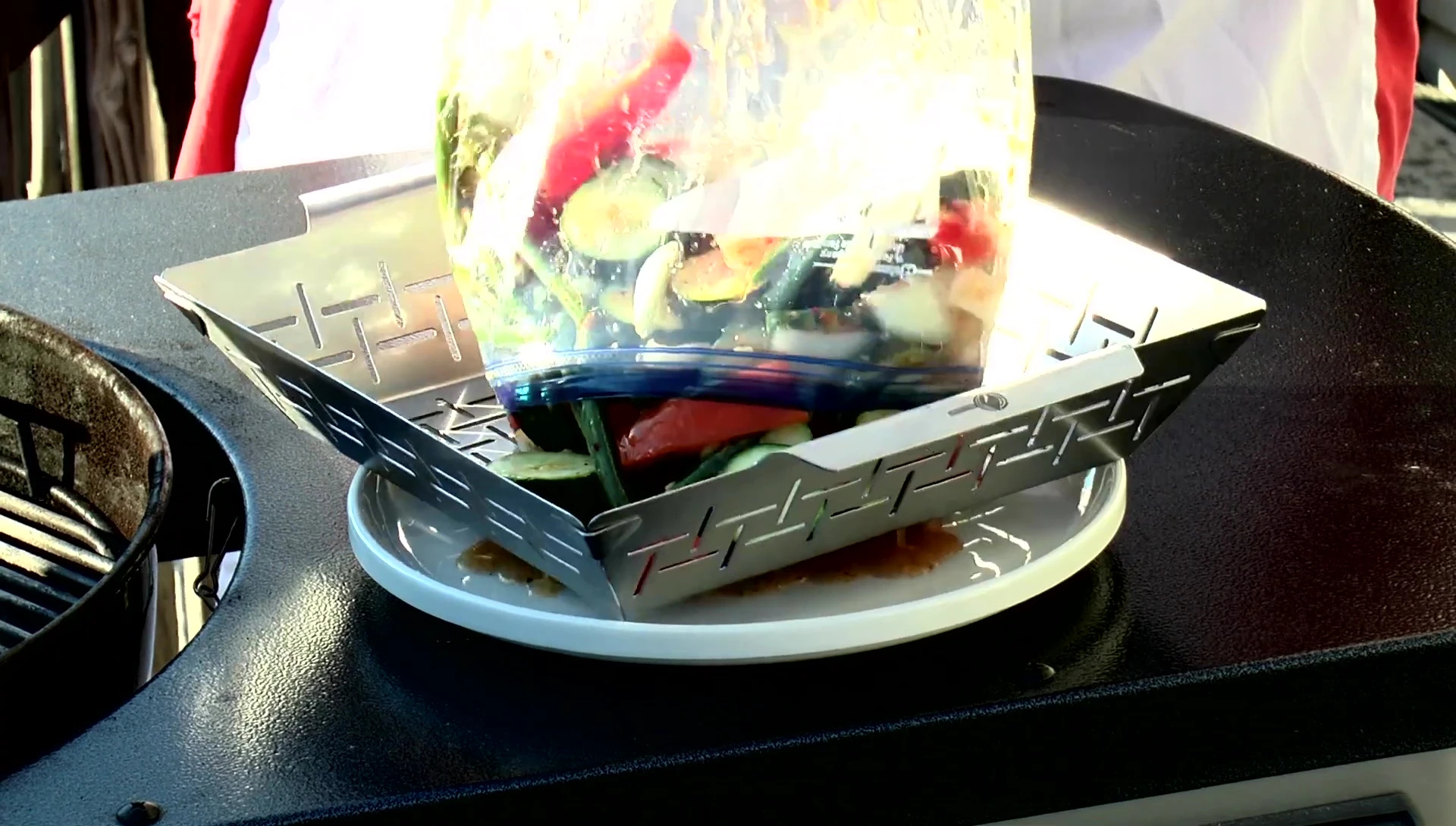 Vegetables being carefully placed in the grill basket.