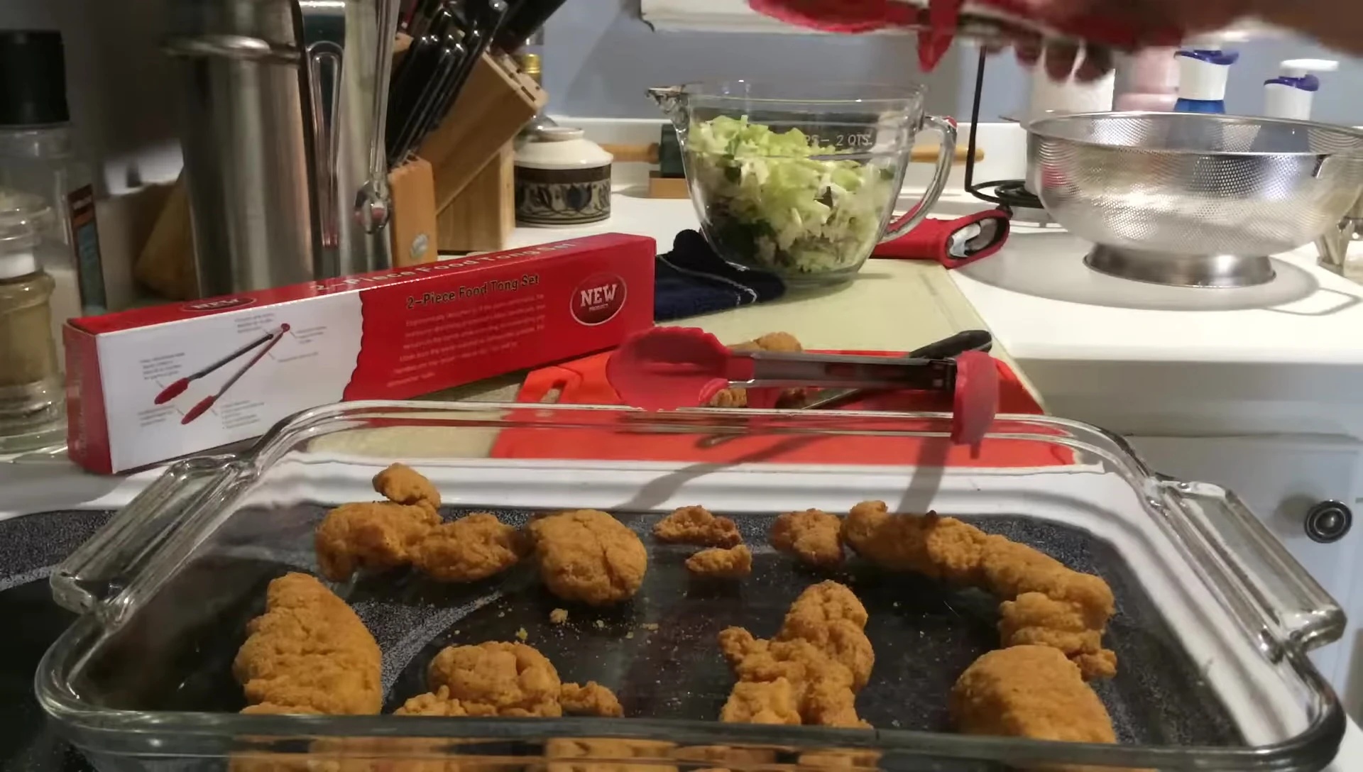 The smaller tongs being used to toss a salad.