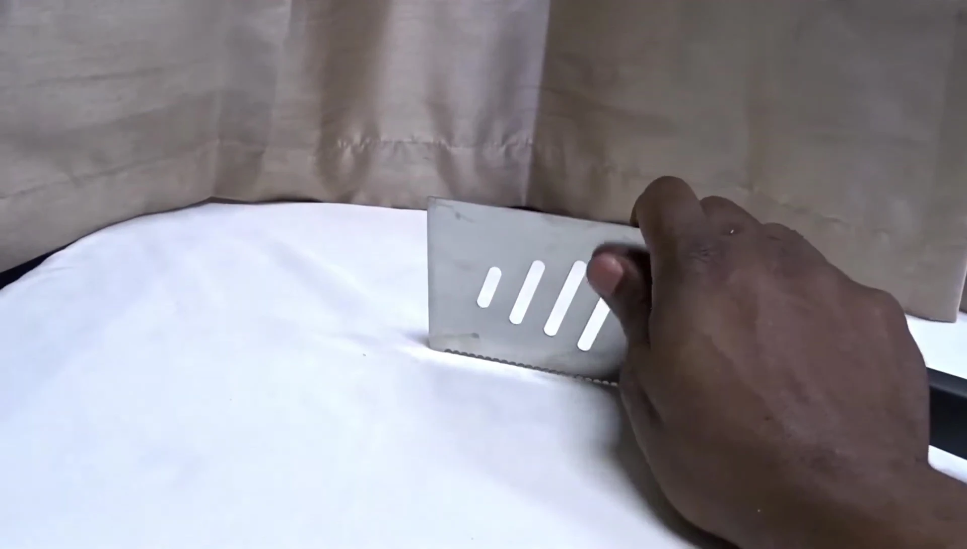 The slotted design of the spatula for draining grease.