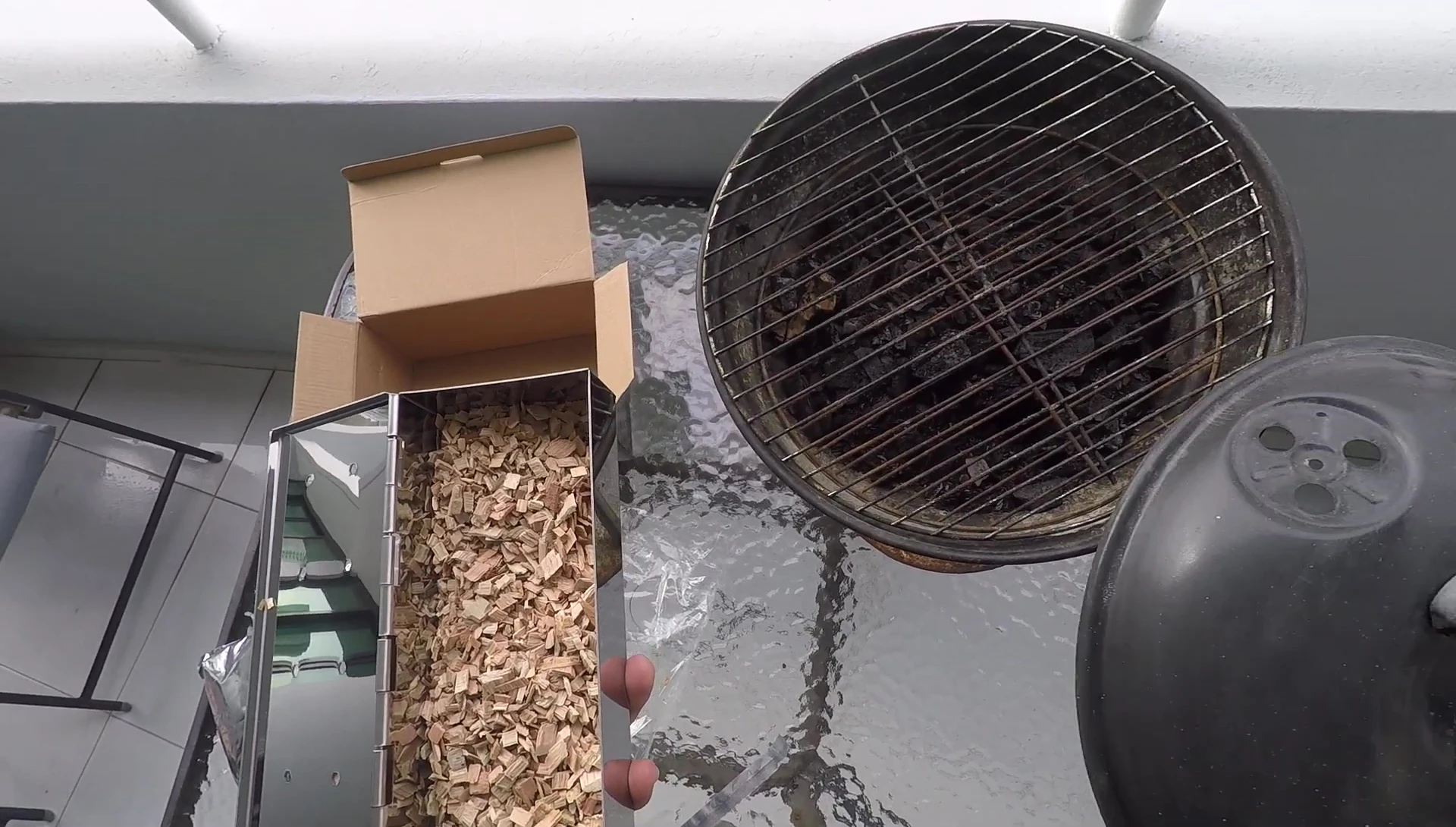 Adding charcoal and wood chips to the smoker box.